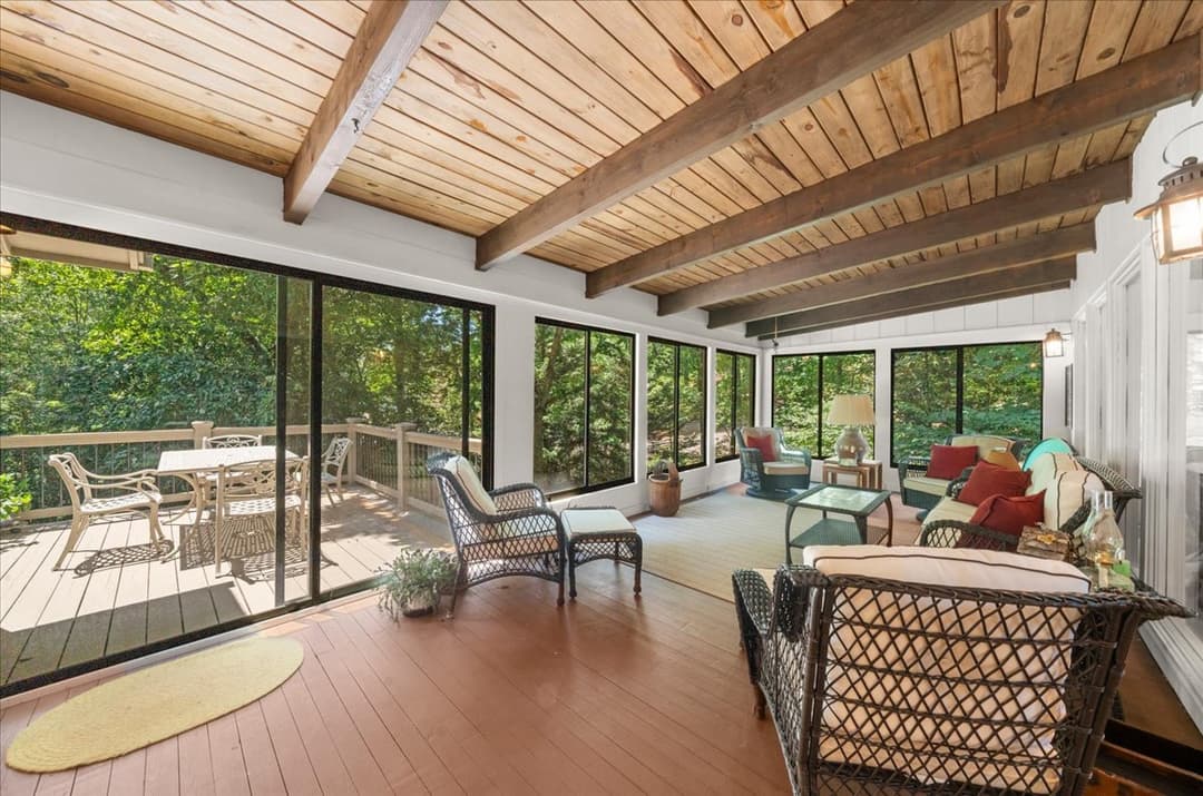 7865 Robin Rd — glass-enclosed screened sunroom with wood-beam ceiling