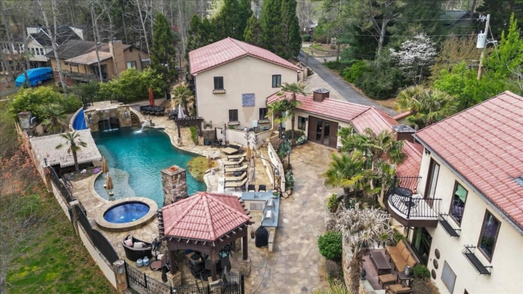 Aerial view of a Mediterranean-style home with resort-style pool, spa and gazebo