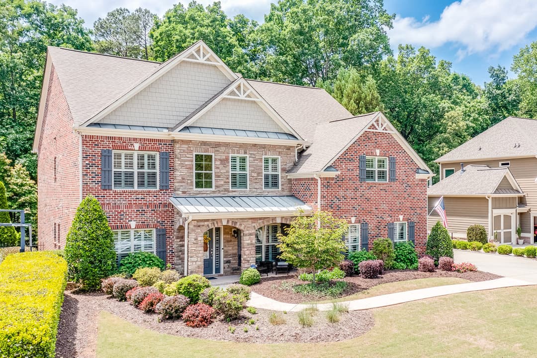 Brick and stone two-story home with a covered entry porch and landscaped yard