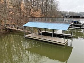 Covered single-slip boat dock with a gangway on the lake