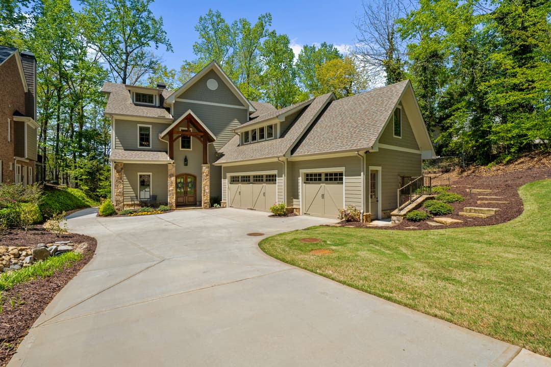 Modern Lake Lanier lake home exterior with manicured landscaping and stacked-stone accents — Forsyth County, GA