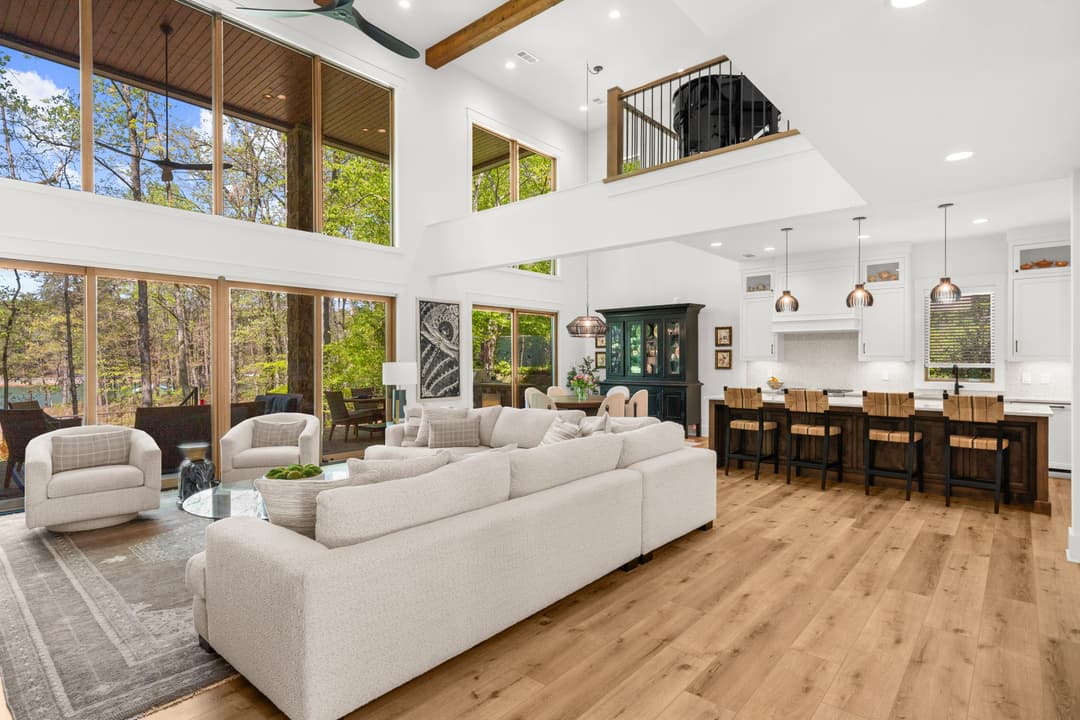 Main living room with vaulted ceilings, fireplace, and lake views