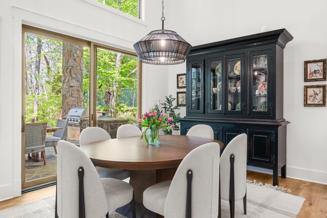 Designer kitchen with marble countertops, dark cabinetry, and brass hardware