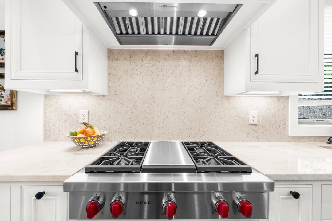 Kitchen detail with subway-tile backsplash and professional-grade gas range