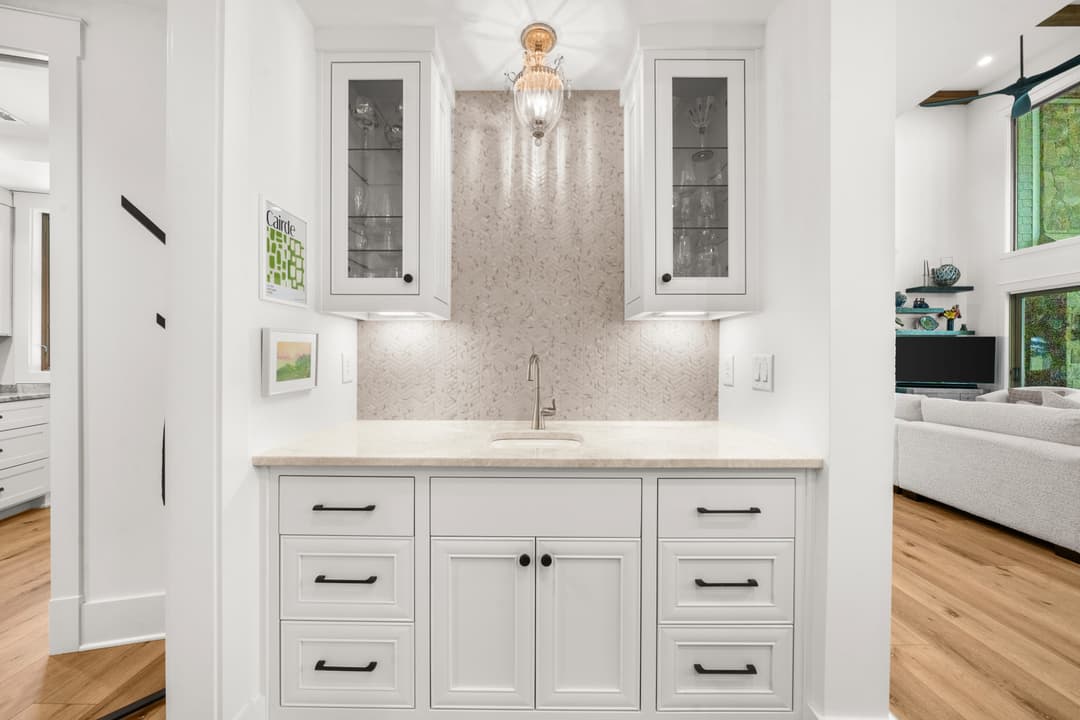 Spa-style primary bathroom with freestanding tub, marble floors, and dual vanities