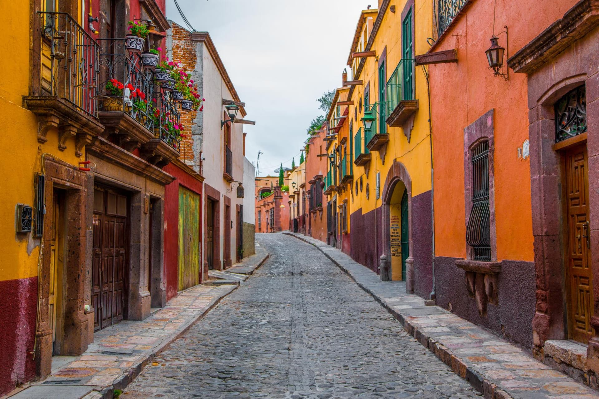Colorful colonial facades along a cobblestone street in San Miguel de Allende