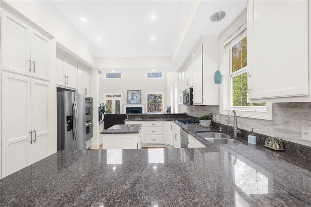 Kitchen with granite countertops, gas cooktop, and double ovens